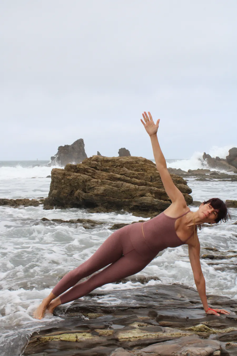 Arpi in a flowing backbend stretch by the ocean