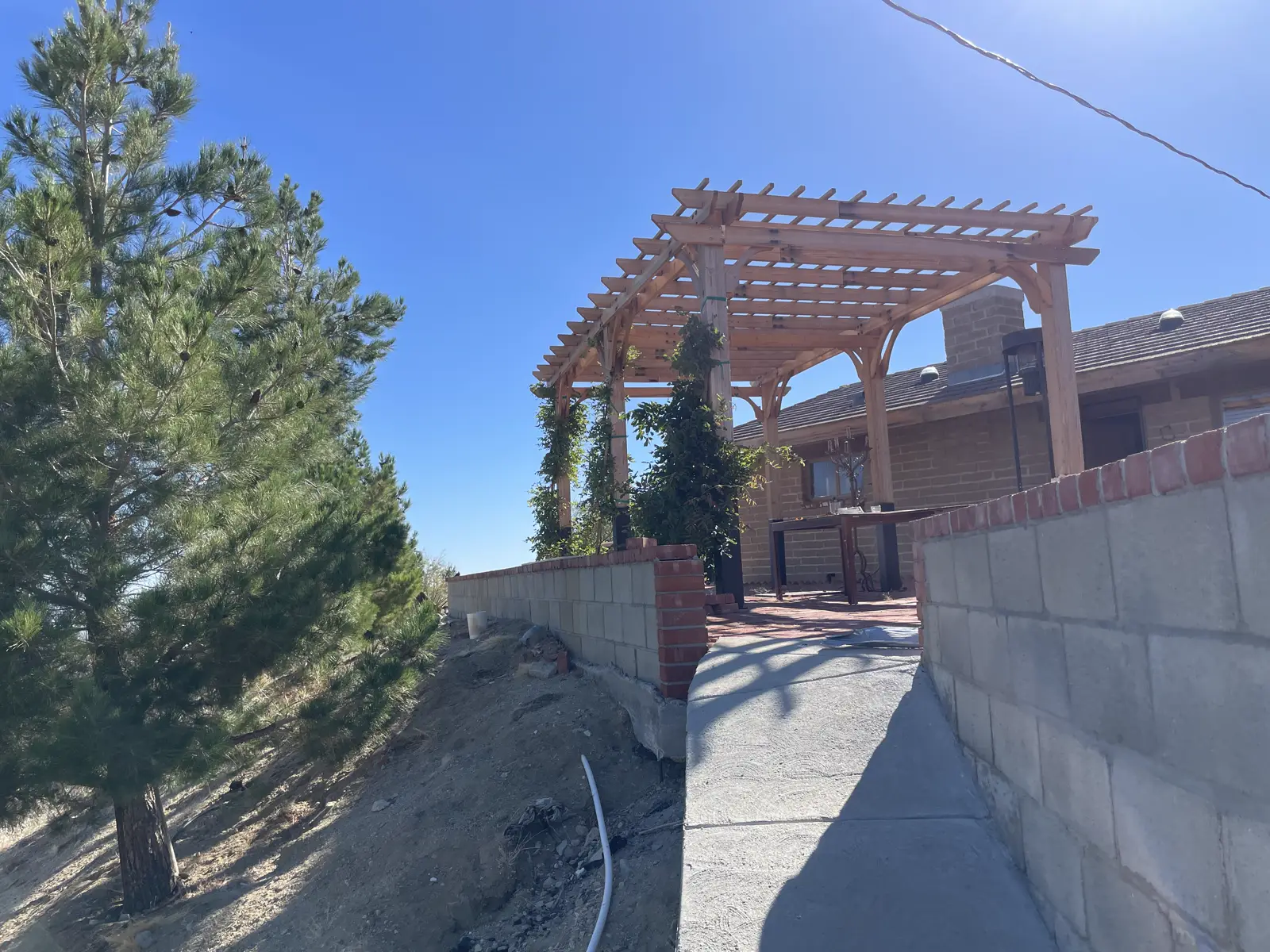 Wooden pergola over an outdoor dining patio at the retreat house